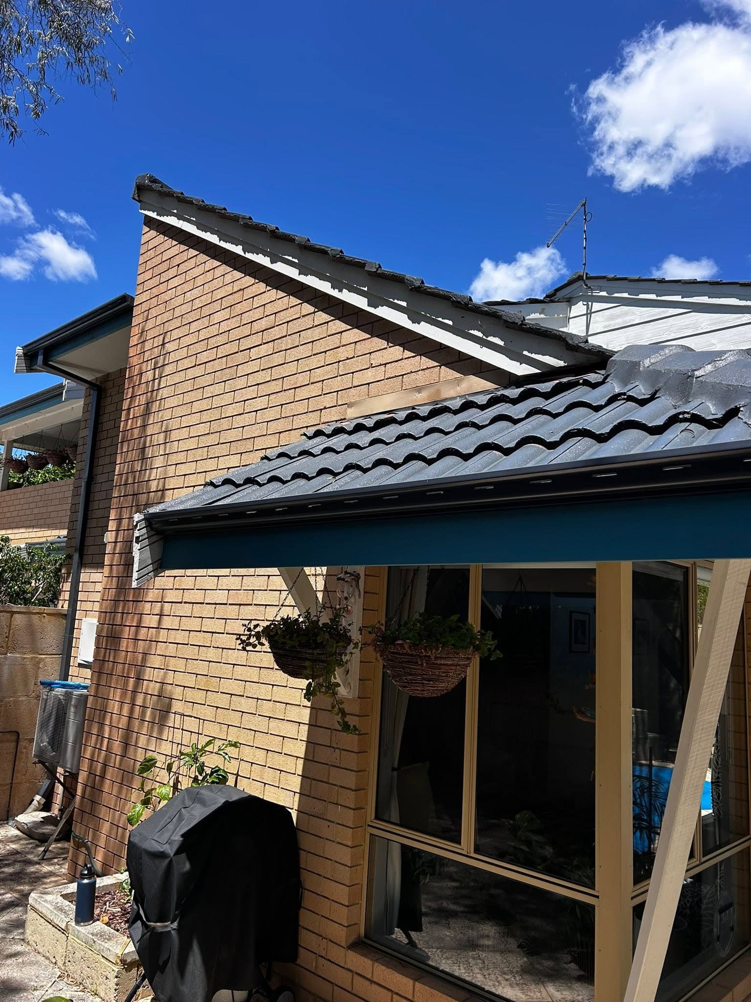 Brick home with a charcoal tiled roof, new fascia and guttering