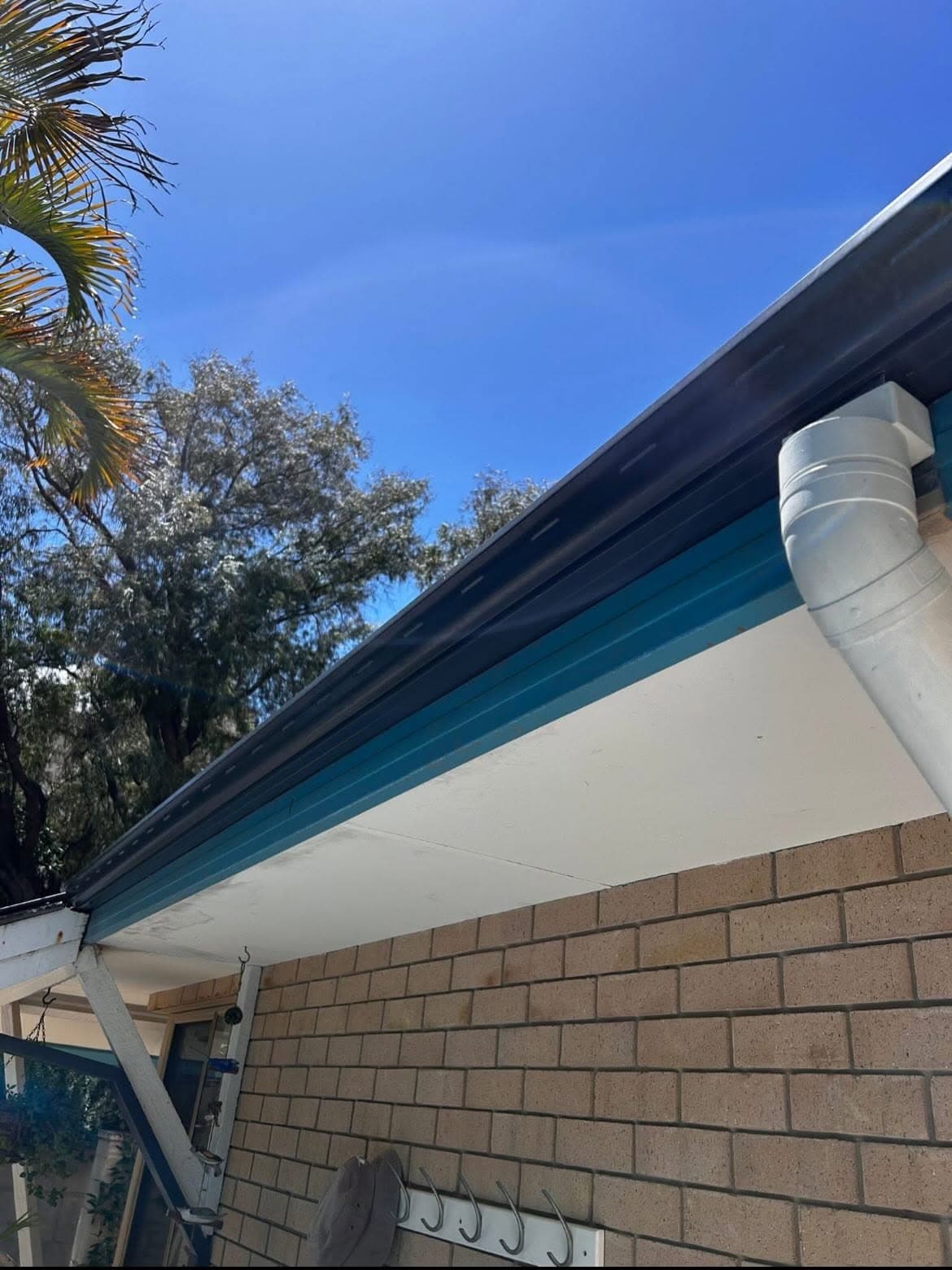 Newly fitted gutter, fascia and downpipe along a home's eave