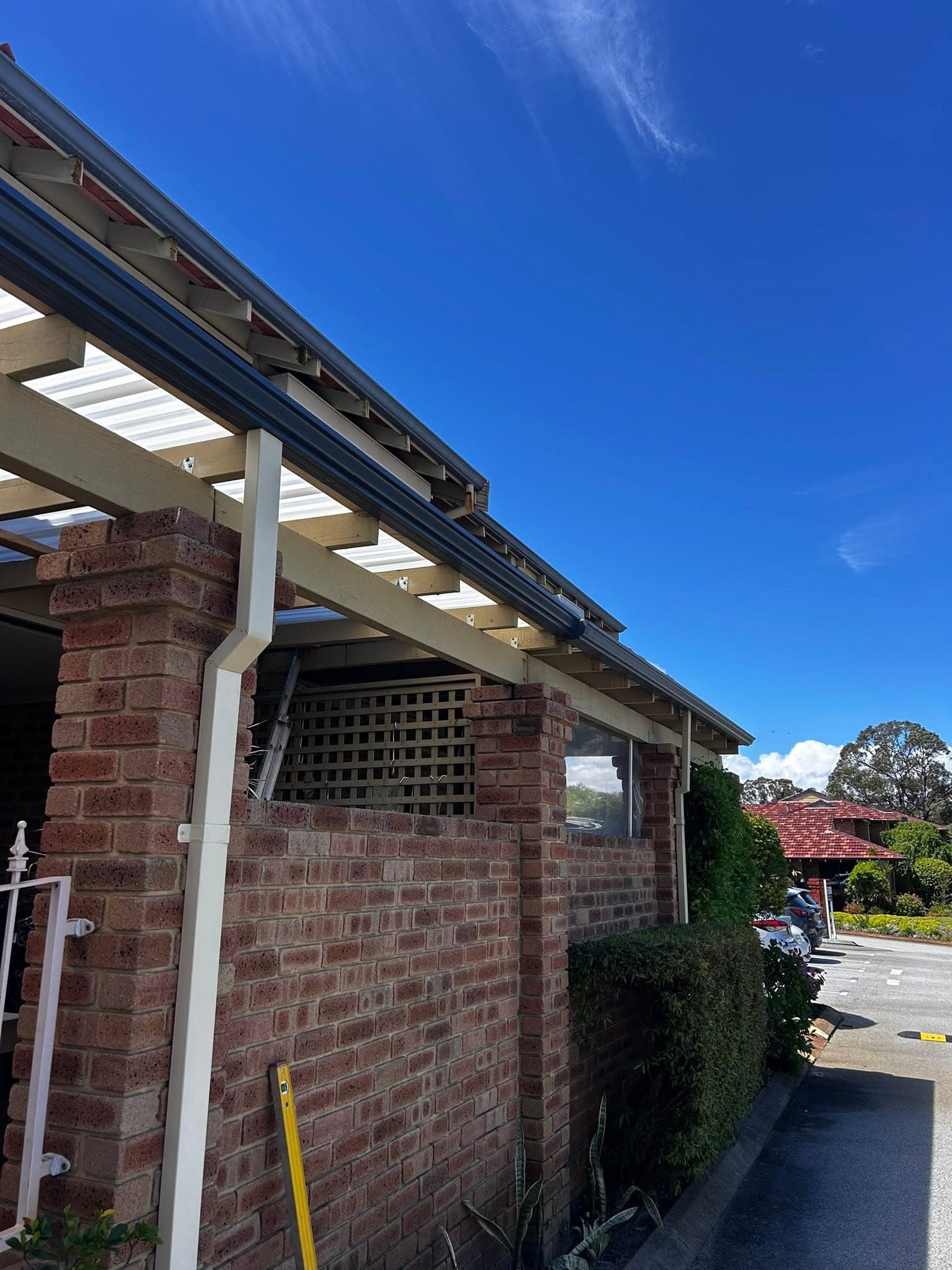 New guttering fitted along a patio roofline supported by brick columns